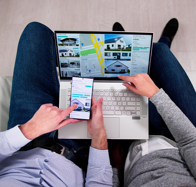 2 Personen mit Laptop auf dem Schoß auf Wohnungssuche